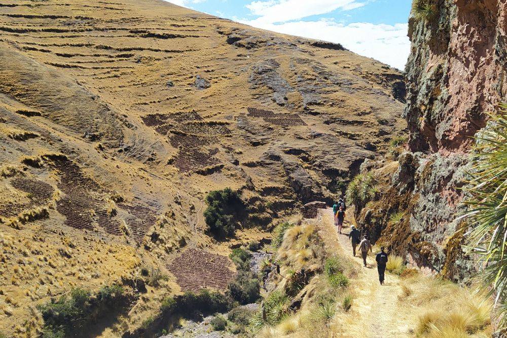 Menschen wandern im Heiligen Tal Peru zu den Huchuy Qosqo Ruinen